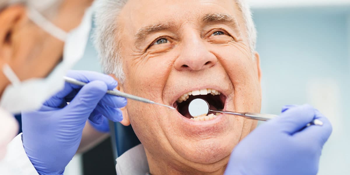 Mature man in dental chair oral surgery